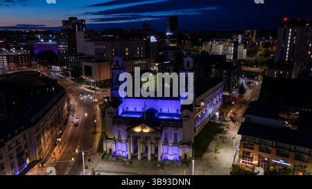 Vue aérienne de l'hôtel de ville de Leeds illuminé en violet au crépuscule, entouré par les feux de la ville et la circulation, mettant en valeur le paysage urbain dynamique de Leeds, Royaume-Uni Banque D'Images