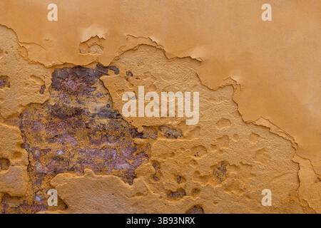 Peler le plâtre jaune sur le mur de briques Banque D'Images