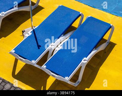 Chaises longues bleues au soleil Banque D'Images