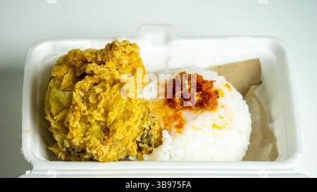 Ayam geprek (poulet frit croustillant épicé indonésien) avec riz sur polystyrène Banque D'Images