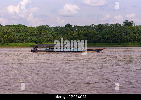 Bateau voyageant le long de la rivière Madre de Dios dans la forêt amazonienne péruvienne Banque D'Images