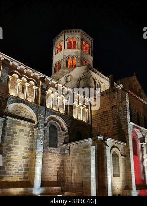 Illuminé Abbatiale Saint Austremoine à Issoire la nuit, mettant en valeur le Puy de Dôme en Auvergne Rhône Alpes région de France Banque D'Images
