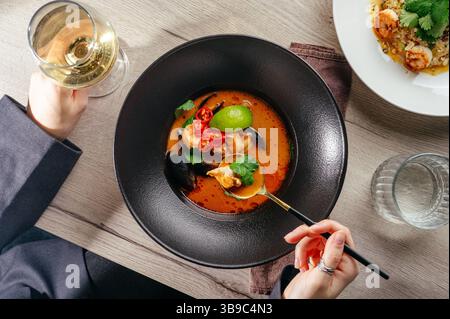 Soupe Tom Yum avec un verre de vin dans un restaurant Banque D'Images