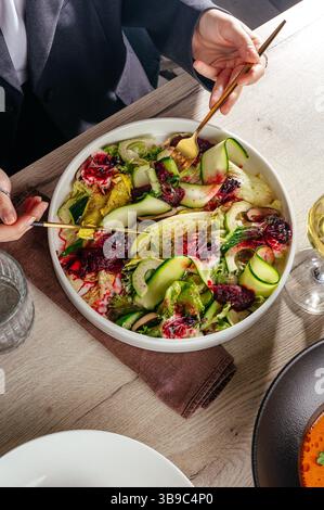 fille mangeant de la salade au restaurant. salade de courgettes Banque D'Images