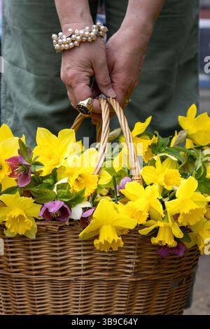 Marcher avec panier de fleurs dans un pantalon en lin vert Banque D'Images
