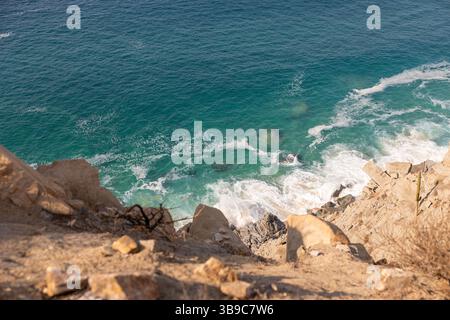 Falaise rocheuse avec des vagues turquoises s'écrasant à Cabo Banque D'Images