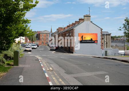 Derry / Londonderry, Irlande du Nord - 7 mai 2025 : vue sur les rues du domaine de la fontaine avec des bordures de trottoir rouges blanches et bleues et une murale militaire Banque D'Images