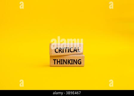 Symbole de pensée critique. Blocs en bois avec des mots pensée critique. Beau fond jaune. Concept d'entreprise et de pensée critique. Copier l'espace. Banque D'Images