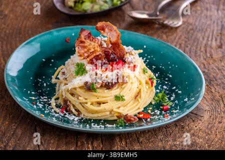Spaghetti Carbonara avec salade sur bois Banque D'Images