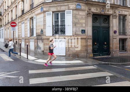 Mouvement flou d'un jogger à l'angle de la rue Mansart et de la rue Blanche dans le 9ème arrondissement de Paris, France Banque D'Images