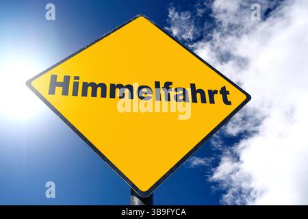 Allemagne - 9 mai 2025 : PHOTOMONTAGE, panneau jaune avec l'inscription : Ascension, devant un ciel bleu *** FOTOMONTAGE, Gelbes Schild mit der Aufschrift : Himmelfahrt, vor blauem Himmel Banque D'Images