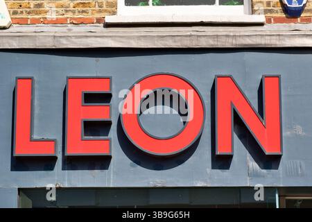 Gros plan du mot « LEON » en grandes lettres rouges en trois dimensions sur fond gris, monté sur la façade d'un bâtiment à Kingston, au Royaume-Uni. Banque D'Images