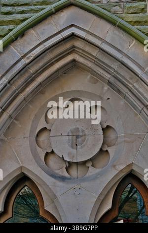 Plan détaillé d'un élément architectural arqué présentant une construction en pierre avec un motif floral circulaire à Harrogate, Yorkshire, Royaume-Uni. Banque D'Images