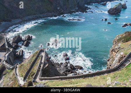 Vue imprenable d'en haut d'un chemin sinueux menant à l'îlot Gaztelugatxe, situé au milieu de la côte rocheuse de Bermeo dans le pays Basque, en Espagne. Banque D'Images