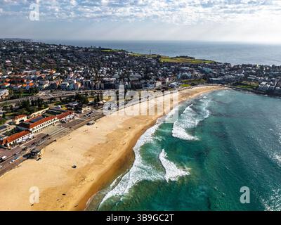 Vue aérienne d'une belle ville côtière avec plage de sable, océan bleu et quartier résidentiel à Sidney, Australie. Les vagues chevauchent doucement le rivage, créant ainsi Banque D'Images