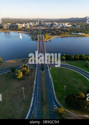 Vu d'en haut, un drone capture le magnifique paysage urbain de Canberra, en Australie, avec un pont autoroutier proéminent traversant la grande rivière Molonglo, surroun Banque D'Images