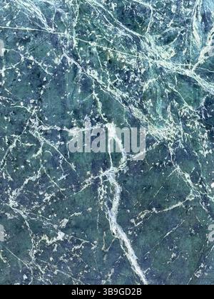 Texture de marbre vert avec des motifs veineux blancs complexes, mettant en valeur un aspect naturel et élégant. Idéal pour les arrière-plans, le design d'intérieur, Banque D'Images