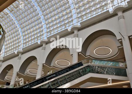 Prise de vue intérieure regardant un plafond de verre à motif quadrillé au-dessus de l'intérieur d'un bâtiment avec escaliers mécaniques, arches et anneaux suspendus à Kingston, Banque D'Images