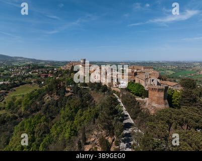 Vue aérienne de Treia, Italie, mettant en valeur son architecture historique entourée d'une végétation luxuriante. La charmante ville offre un paysage pittoresque sous Banque D'Images