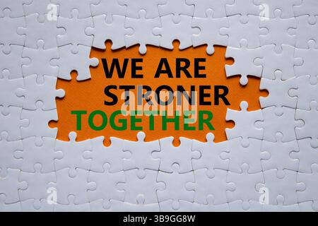 Nous sommes plus forts ensemble symbole. Puzzle blanc avec des mots nous sommes plus forts ensemble. Beau fond orange. Nous sommes plus forts ensemble concept. Copier Banque D'Images