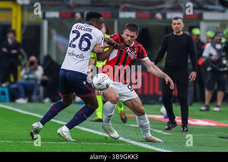 Milan, Italie. 09 mai 2025. Luka Jovic de l'AC Milan concourt pour le ballon avec Jhon Lucumi du Bologna FC lors du match de football de Serie A 2024/25 entre l'AC Milan et le Bologna FC au San Siro Stadium crédit : Independent photo Agency/Alamy Live News Banque D'Images