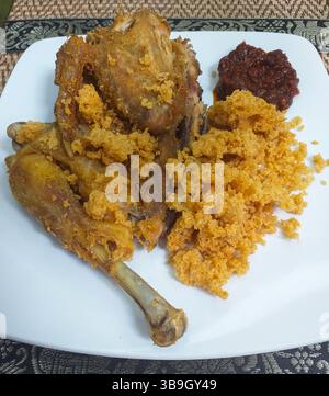 Nasi Goreng avec un poulet à moitié frit. kremes et sambal piment rouge épicé. Banque D'Images