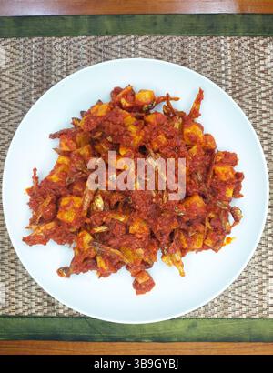 Teri Kentang Balado, un plat épicé d'anchois et de pommes de terre balado dans une sauce épicée au piment rouge d'Indonésie. Banque D'Images