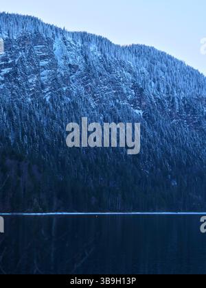 Montagne enneigée se reflète dans le lac calme à l'aube dans un cadre sauvage serein Banque D'Images