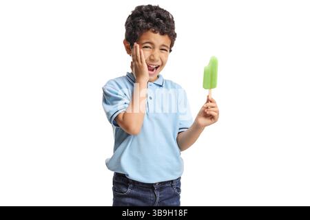 Garçon avec une crème glacée sucette tenant sa joue et ayant un mal de dents isolé sur fond blanc Banque D'Images