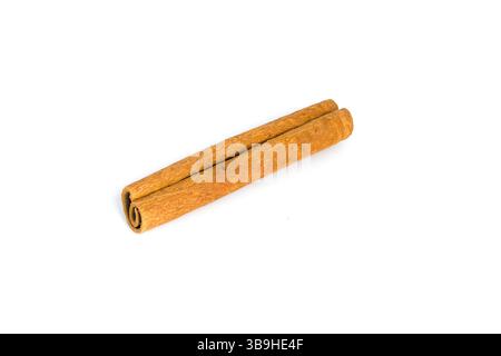 Fragments d'écorce de cannelle soigneusement disposés sur blanc, en se concentrant sur leur texture grossière, leurs motifs naturels et leurs tons chauds, parfaits pour les épices et la cuisson vi Banque D'Images