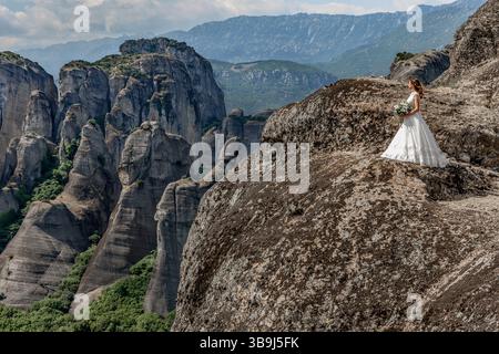 Belle mariée sur un sommet de montagne précaire dans Météores, Grèce Banque D'Images