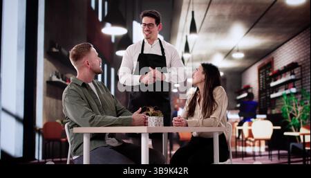 Célébrant l'anniversaire, homme et femme assis à l'élégante table du dîner. Banque D'Images