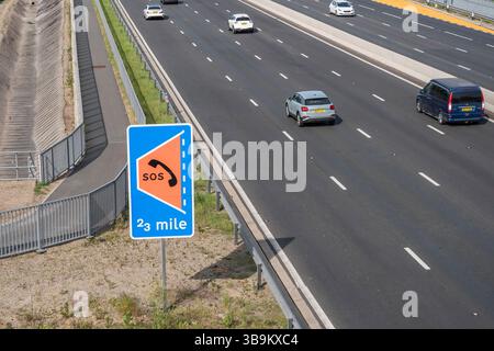 Voitures passant un panneau de refuge d'urgence SOS sur l'autoroute M4, Dorney, Royaume-Uni. Banque D'Images