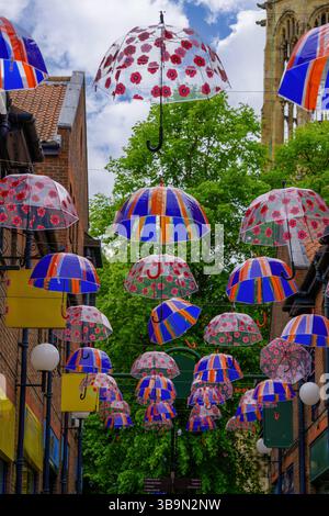 Les coquelicots rouges et les Union Jacks ornaient des parapluies à motifs à Coppergate, York. Banque D'Images