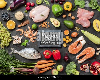 Régime alimentaire Pegan conept. Plus Vegan diet paléo ingrédients alimentaires - légumes, fruits, viande et poisson sur fond sombre. Vue supérieure ou télévision lay Banque D'Images
