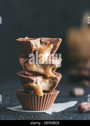 Pile de vegan au chocolat avec le caramel sur le tableau noir. Des plats végétariens avec des tasses chocolat Caramel chocolat cacao. Idées et recettes pour h Banque D'Images