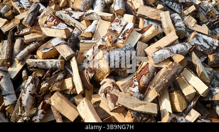 Pile de bois de chauffage de bouleau avec bloc de coupe à la main. Bois de chauffage haché pour l'hiver. Beaucoup de bois de chauffage - récolte de bois pour chauffer la maison. Pho. Horizontale Banque D'Images