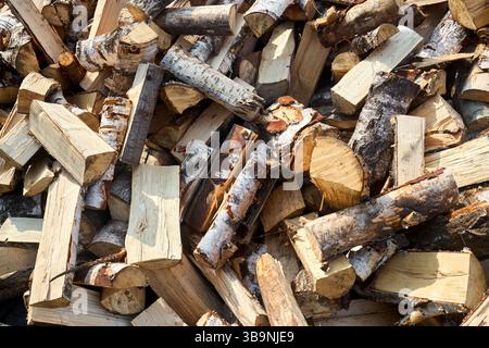 Pile de bois de chauffage de bouleau avec bloc de coupe à la main. Bois de chauffage haché pour l'hiver. Beaucoup de bois de chauffage - récolte de bois pour chauffer la maison. Pho. Horizontale Banque D'Images