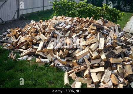 Pile de bois de chauffage de bouleau avec bloc de coupe à la main. Bois de chauffage haché pour l'hiver. Beaucoup de bois de chauffage - récolte de bois pour chauffer la maison. Pho. Horizontale Banque D'Images