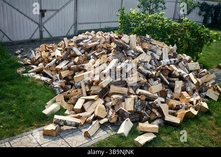 Pile de bois de chauffage de bouleau avec bloc de coupe à la main. Bois de chauffage haché pour l'hiver. Beaucoup de bois de chauffage - récolte de bois pour chauffer la maison. Pho. Horizontale Banque D'Images