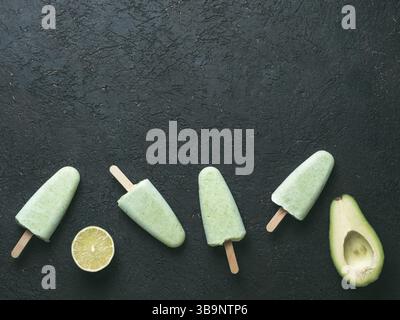 Végétalien premières maison lime avocat ma glace. Sans sucre, sans produits laitiers, crème glace verte sur fond texturé noir. Copier l'espace. Vue d'en haut. Idées et recettes Banque D'Images