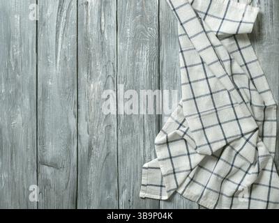 Table en bois gris avec linge de cuisine ou serviette de table en tissu. Nappe bleue sur un vieux plan d'examen en bois gris. Copier l'espace pour le texte. Peut être utilisé comme modèle Banque D'Images