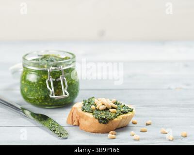 Vue rapprochée du pain baguette avec sauce pesto au basilic frais sur la table en bois gris. Copier l'espace Banque D'Images