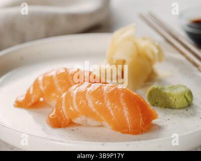 Deux sushi nigiri de saumon sur assiette blanche. Saumon sushi japonais frais servi au wasabi dans un restaurant japonais. La cuisine japonaise comme les sushis de saumon et le sashi Banque D'Images