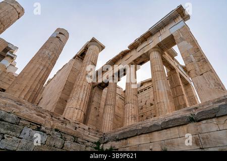 Vue en bas angle sur les majestueuses colonnes de marbre de la Propylaea, l'ancienne porte monumentale de l'Acropole d'Athènes. Banque D'Images