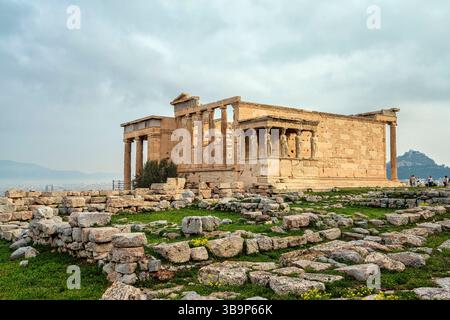 Le temple d'Érechthéion sur l'Acropole d'Athènes, avec les statues emblématiques de Caryatide surplombant les ruines antiques et la ville en contrebas. Banque D'Images