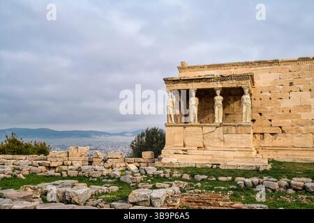 Le temple d'Érechthéion sur l'Acropole d'Athènes, avec les statues emblématiques de Caryatide surplombant les ruines antiques et la ville en contrebas. Banque D'Images