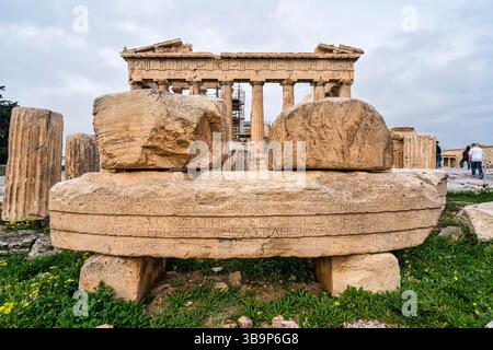 Gros plan de pierres de marbre altérées inscrites sur l'Acropole d'Athènes avec le temple du Parthénon s'élevant en arrière-plan. Banque D'Images