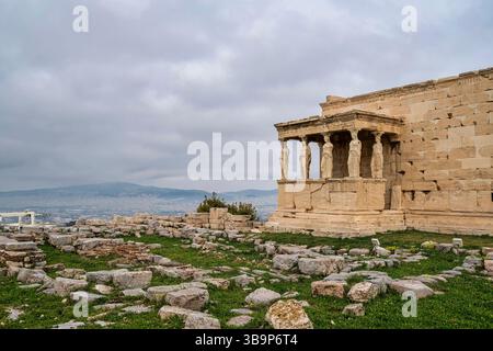 Le temple d'Érechthéion sur l'Acropole d'Athènes, avec les statues emblématiques de Caryatide surplombant les ruines antiques et la ville en contrebas. Banque D'Images