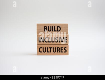 Symbole construire des cultures inclusives. Les blocs de bois avec des mots construisent des cultures inclusives. Beau fond blanc. Entreprise et construire des cultures inclusives. Banque D'Images